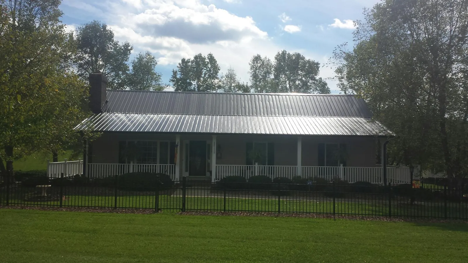 Gray metal roof on a brick ranch with a full width front porch — Gutter Guard Installation work by our crew in Livermore